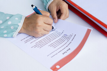 Closeup woman's hands is doing English examination on paper test. Concept : Education. Evaluation....