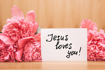 Jesus loves you - card with biblical lettering and pink peony flowers, christian motivation phrase