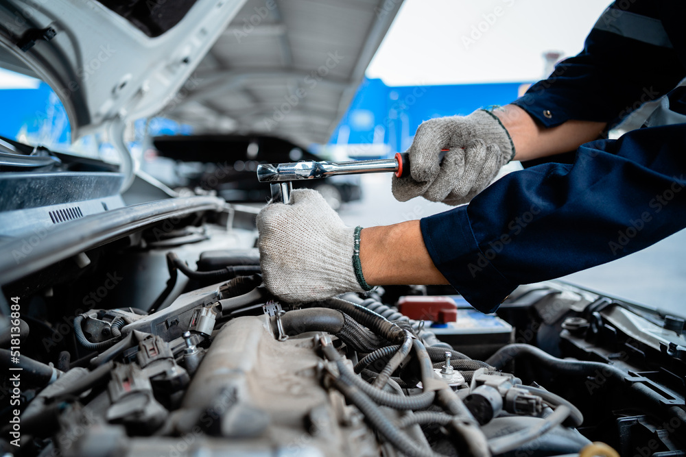 Wall mural close-up of a car mechanic repairing a car in a garage. car safety check the engine in the garage. r