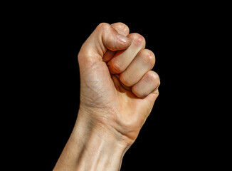 A man's palm is clenched into a fist isolated on a black background. Fist on black background. 