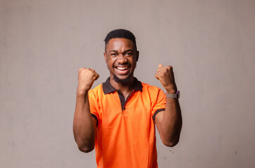 Handsome young Afro-American man employee feeling excited, gesturing actively, keeping fists...