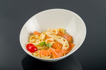 fettuccine with salmon on black glass table
