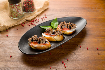 Fototapeta na wymiar Bruschetta with chicken pate and caramelized onion with cheese and tomatoes