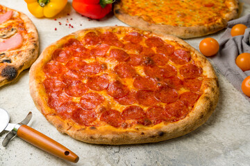 Pepperoni pizza with cheese on stone table side view macro close up