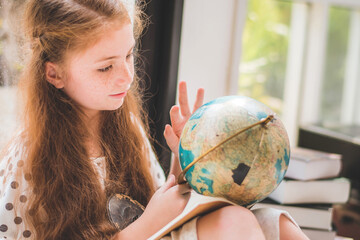 little cute girl studying a world model at home, education concept - Powered by Adobe