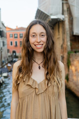 Smiling brunette woman looking at camera in Venice.