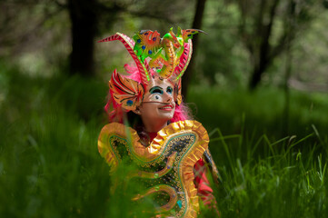 hispanic woman Bolivian, sitting in diablada pillareña costume in the middle of the forest, vertical shoot