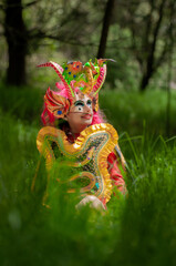 hispanic woman Bolivian, sitting in diablada pillareña costume in the middle of the forest, vertical shoot