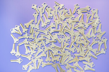 Background of golden keys on a lilac background. Randomly arranged keys on a brown background.
