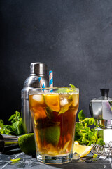 Lavazza mojito mocktail. Strong black espresso coffee cold drink with mojito cocktail, lime, lemon, mint leaves, trendy summer iced beverage on dark background copy pace