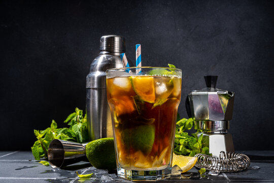 Lavazza mojito mocktail. Strong black espresso coffee cold drink with mojito cocktail, lime, lemon, mint leaves, trendy summer iced beverage on dark background copy pace