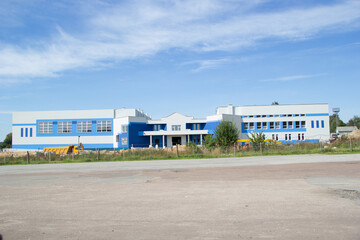 AGAINST THE BACKGROUND OF THE BLUE SKY, THE BUILDING OF THE SPORTS COMPLEX OR THE SWIMMING POOL