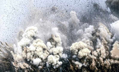 Flying rock and dolomite dust during dynamite blasting on the mining site in the Arabian desert