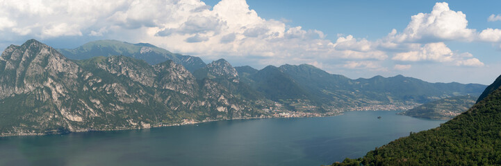 Fototapeta na wymiar Panorama at Lake Iseo and mountains around at sunny day with clouds. Bergamo, Lombardy, Italy.
