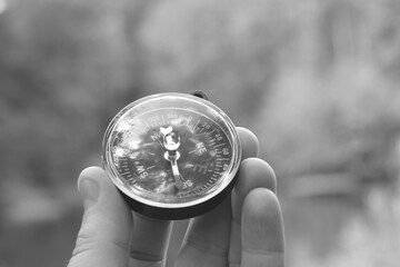 Old classic navigation compass in hand on natural background