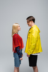 Side view of stylish young couple looking at each other isolated on grey. © LIGHTFIELD STUDIOS