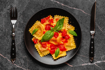 Delicious appetizing ravioli with tomato sauce and basil