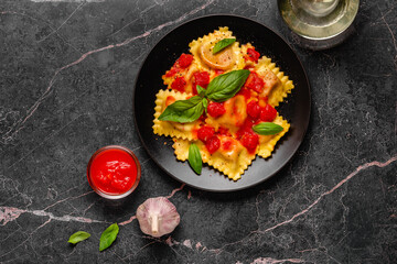 Delicious appetizing ravioli with tomato sauce and basil