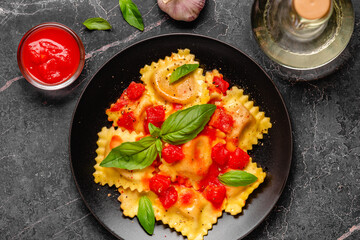 Delicious appetizing ravioli with tomato sauce and basil