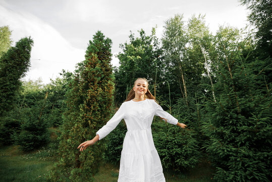 A girl in a white dress runs from the forest