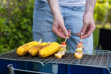 Happy family having barbecue, bbq, party with red wine in outdoor backyard garden of house with happy meal on summer holiday weekend