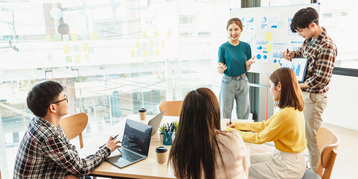 Start up partners discussing the ideas for new strategy of development at nice near the white board flip chart in modern office workspace.