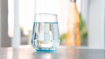 Glass of pure water on kitchen background