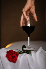 a glass of red wine in the hand of a half-naked beautiful woman