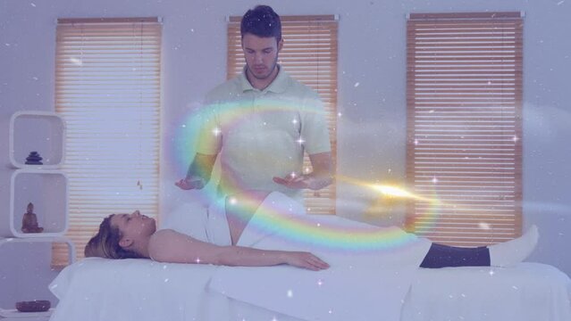 Animation of stars and galaxy moving over caucasian man doing massage to female customer