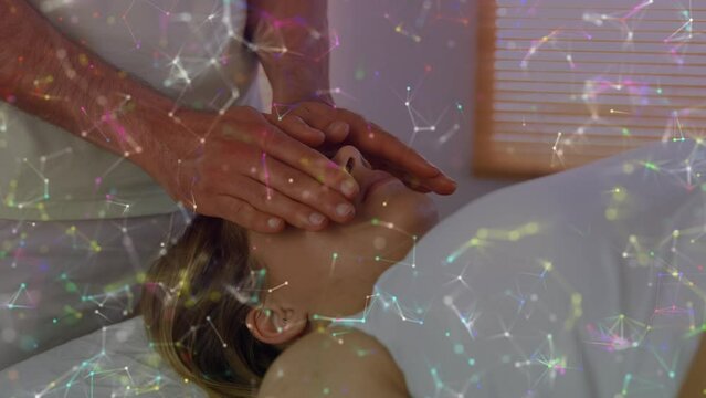 Animation of constellations moving over hands of caucasian man doing massage to female customer