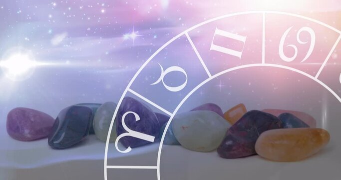 Animation of stars and zodiac moving over stones on white surface