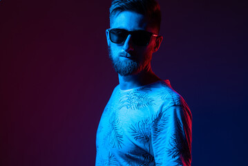 Portrait of a man in sunglasses in neon light