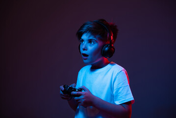 Boy playing with a joystick in headphones © stenkovlad
