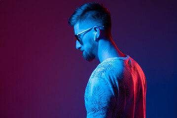 Portrait of a man in sunglasses in neon light