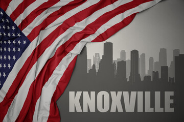 abstract silhouette of the city with text Knoxville near waving colorful national flag of united states of america on a gray background. - obrazy, fototapety, plakaty
