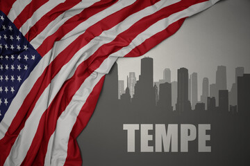 abstract silhouette of the city with text Tempe near waving colorful national flag of united states of america on a gray background.