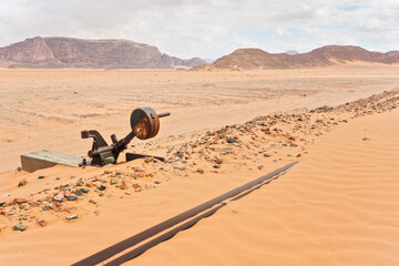 Old rusty unused railroad switch at Wadi Rum train station, tracks covered with sand near, desert...