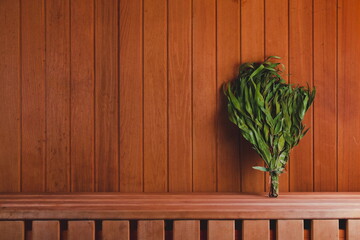 Dry eucalyptus broom on a wooden shelf in the sauna. Copy Space. Empty Space - obrazy, fototapety, plakaty