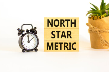 North star metric symbol. Concept words North star metric on wooden blocks on a beautiful white...