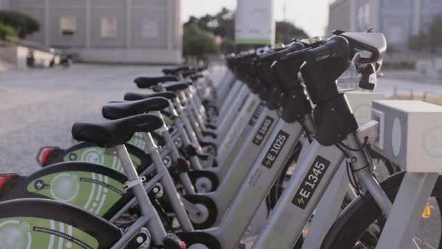 New bike sharing system along the streets of the city. Group of bikes ready to use. Bicycle rental service on city road. Public green transportation. Portugal, Lisboa. June 16, 2022.