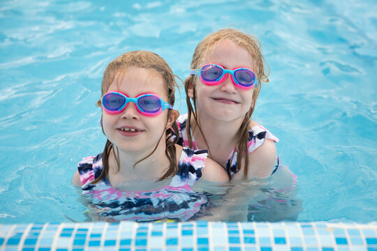 Lovely smiling children in swimming pool wearing diving goggles