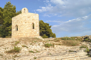Fototapeta na wymiar Restored religious church wall in Verudela on a rocky seashore