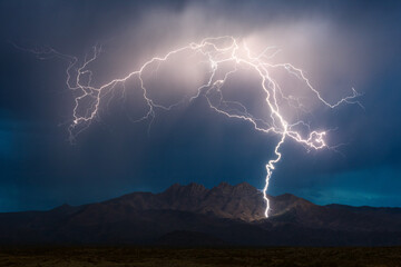 A lightning bolt strikes a mountain in a storm