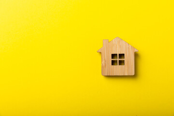 House model and keys on yellow background, flat lay. Housewarming. Real estate investment concept....