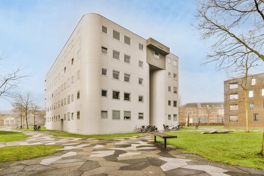 Contemporary building facades near green grass under cloudy sky