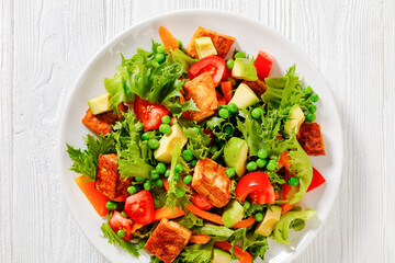 tofu salad with greens and vegetables on plate
