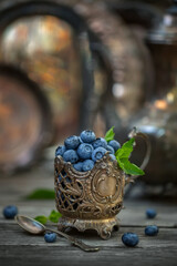 Blueberries in an old silver cup, vintage style. Soft, selective focus.