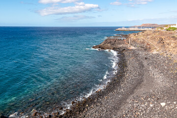 Fototapeta na wymiar Panoramic view on a pebble stone beach Playa de San Blas near Los Abrigos, Tenerife, Canary Islands, Spain, Europe, EU. Coastline of the Atlantic Ocean. Crystal blue lagoon with no people. Vacation