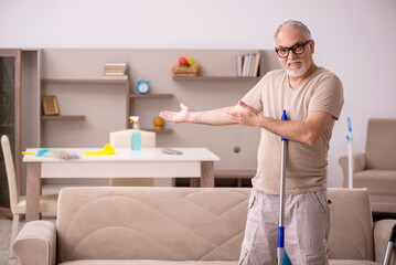 Old man doing housework at home