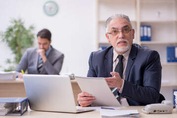 Fototapeta premium Two male employees working in the office